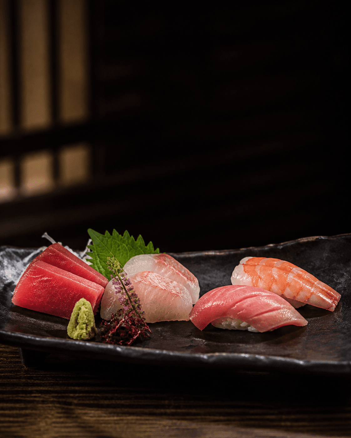 Sushi e sashimi su ceramica scura